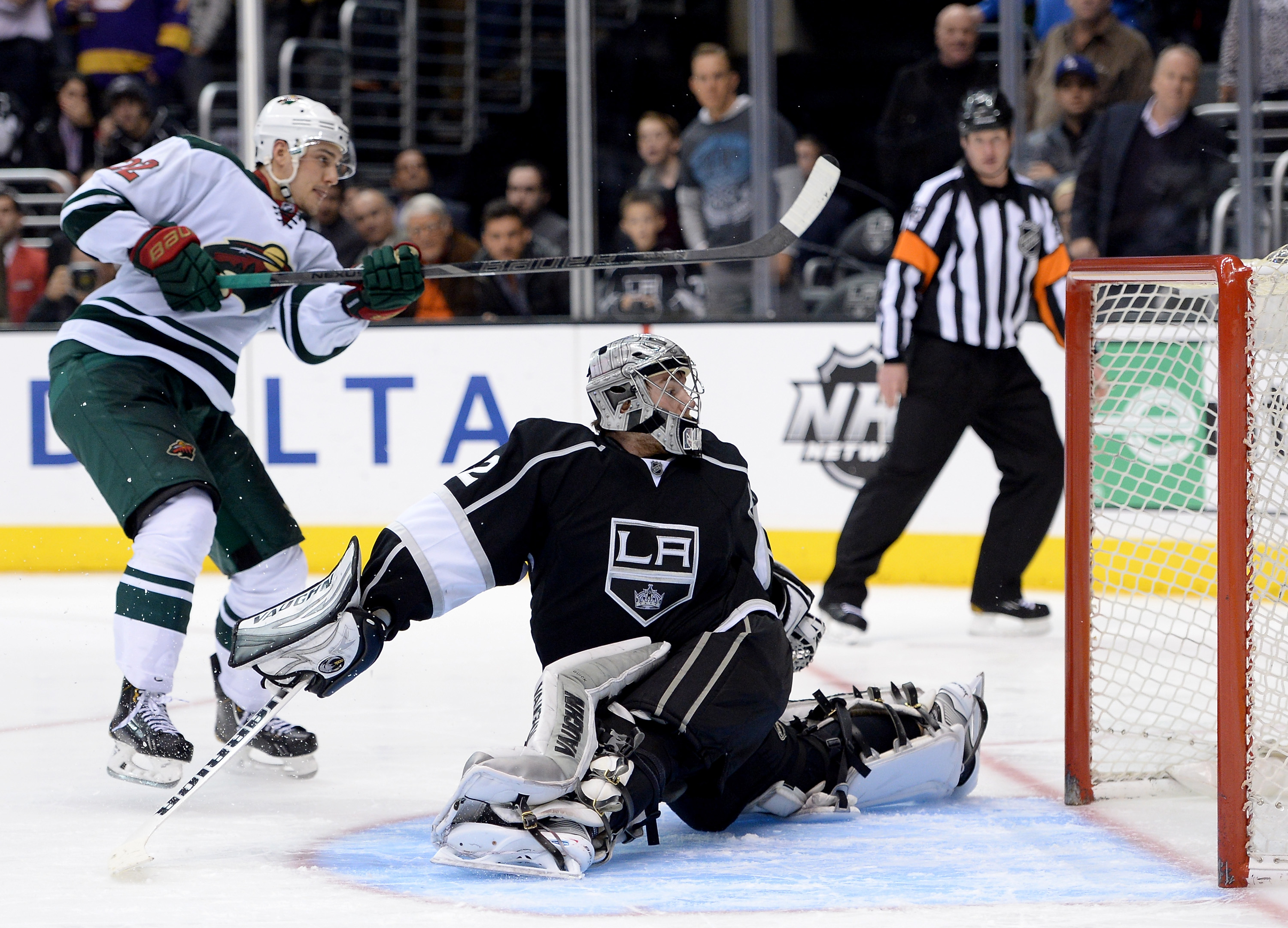 Jonathan Quick #32 of the Los Angeles Kings is spun around by Nino Niederreiter #22 of the Minnesota Wild who scores for a 2-1 win during sudden death shootout at Staples Center on January 7, 2014 in Los Angeles, California. (credit: Harry How/Getty Images) 