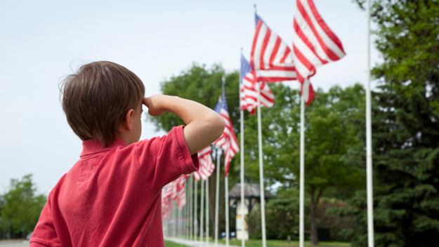 Child Saluting American Flag (Photo Credit: Thinkstock) 