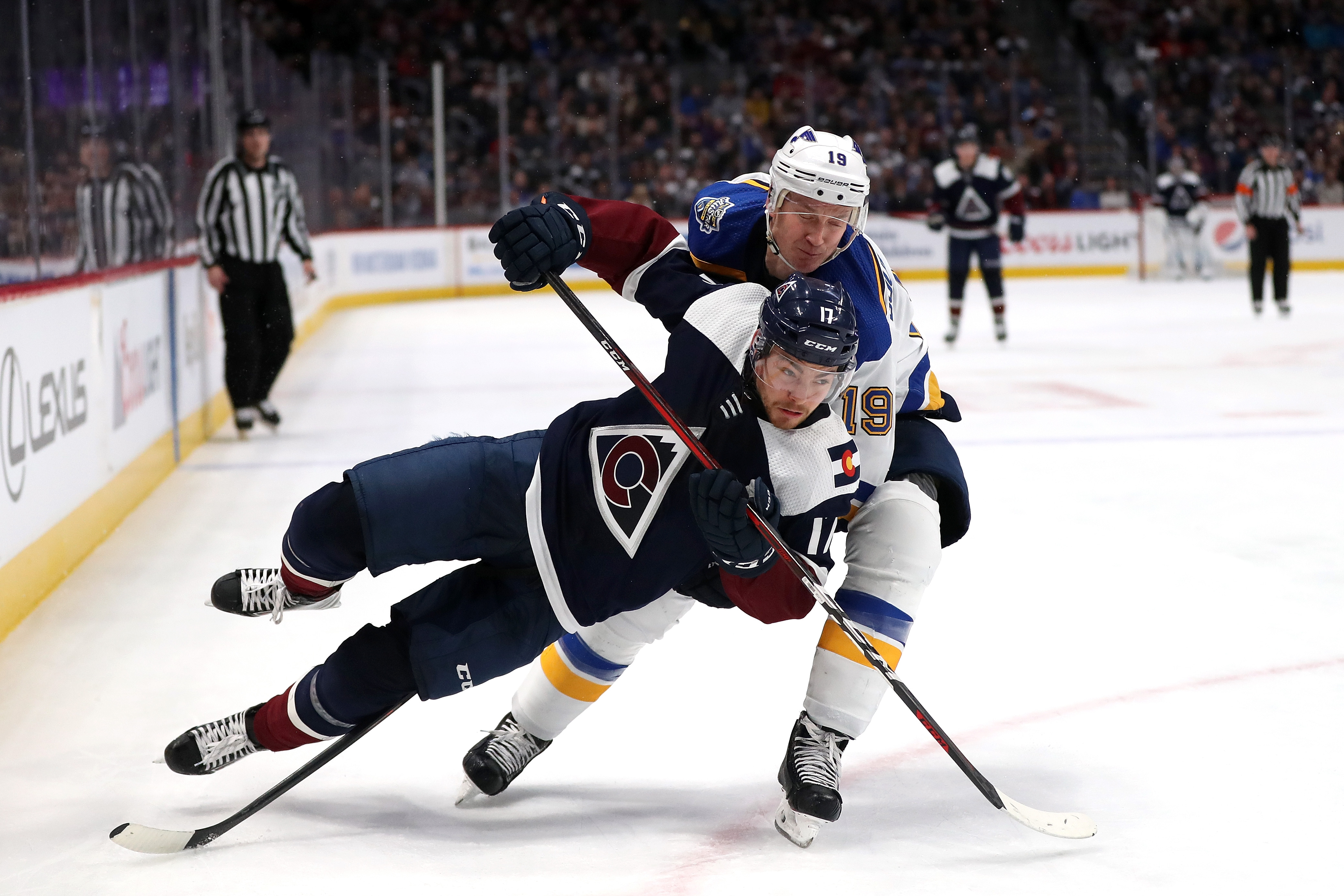 Tyson Joist of the Colorado Avalanche is tripped by Jay Bouwmeester of the St...