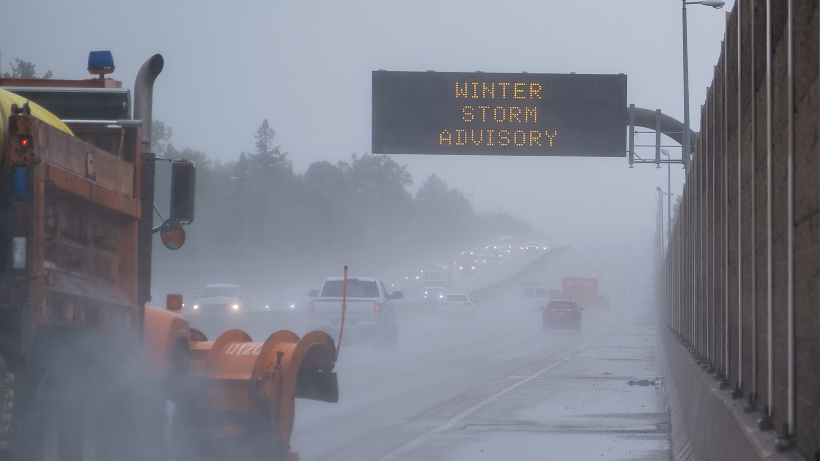 A snowplow drives along Highway 36 as a sign warns of the winter weather on Sept. 8, 2020.