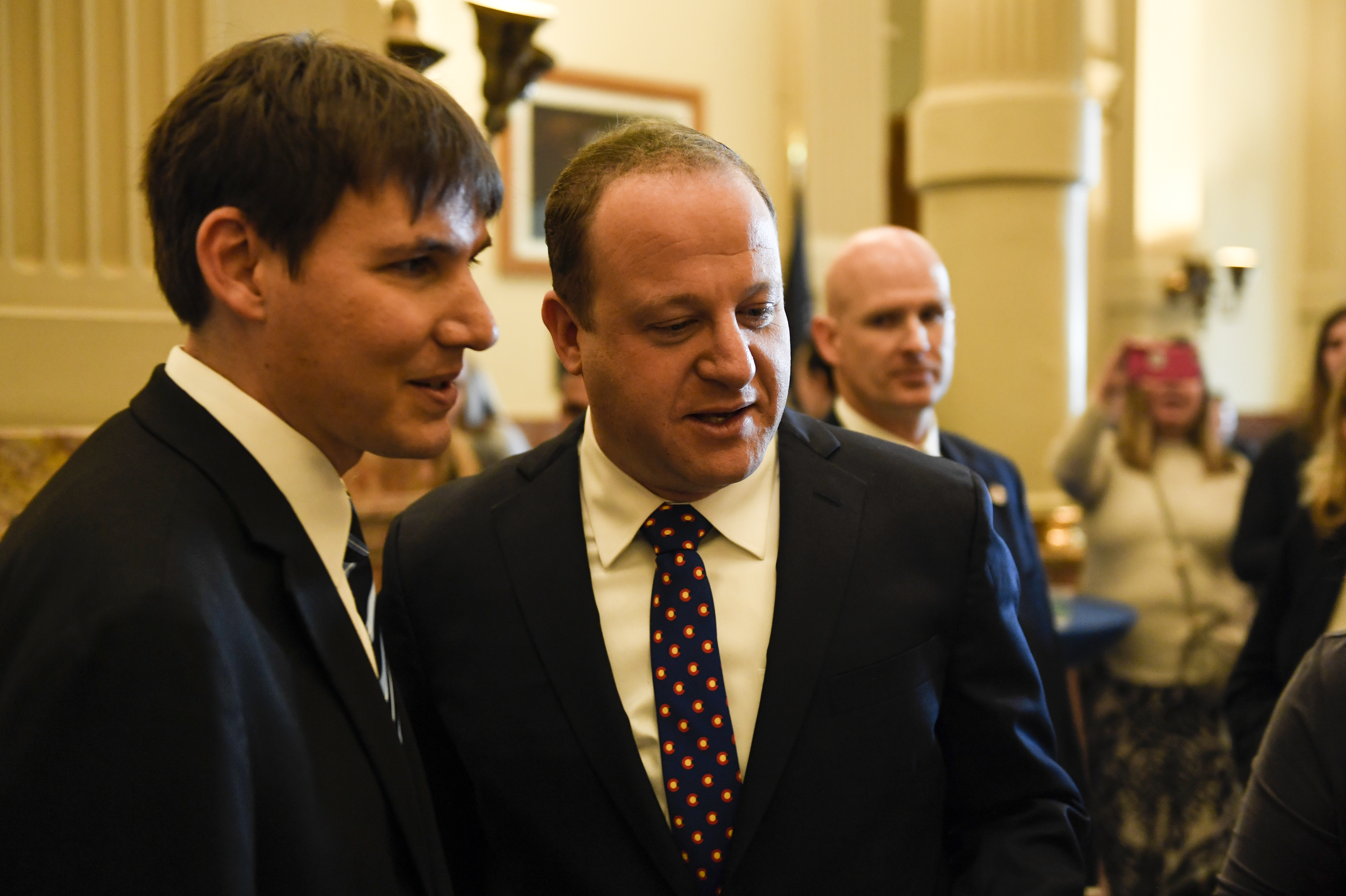 Gov. Jared Polis and his partner, Marlon Reis (right), look at student art on display after his inauguration at the Colorado State Capitol on Jan. 8, 2019.