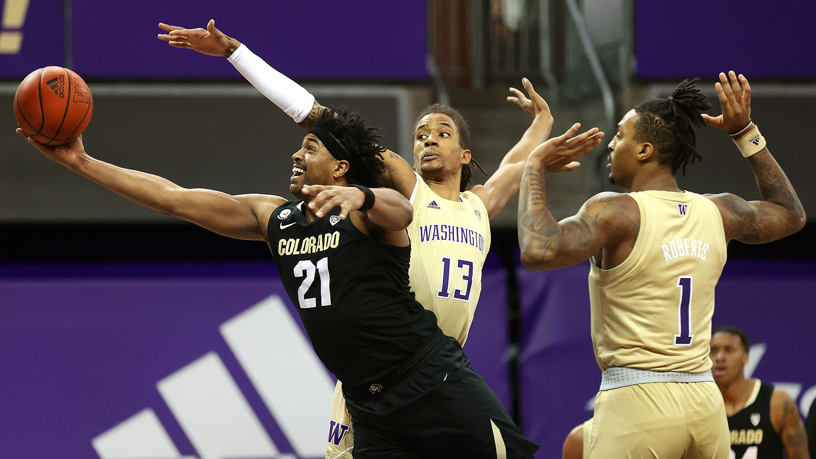 Evan Battey #21 of the Colorado Buffaloes takes a shot against Hameir Wright #13 and Nate Roberts #1 of the Washington Huskies at Alaska Airlines Arena on January 20, 2021.
