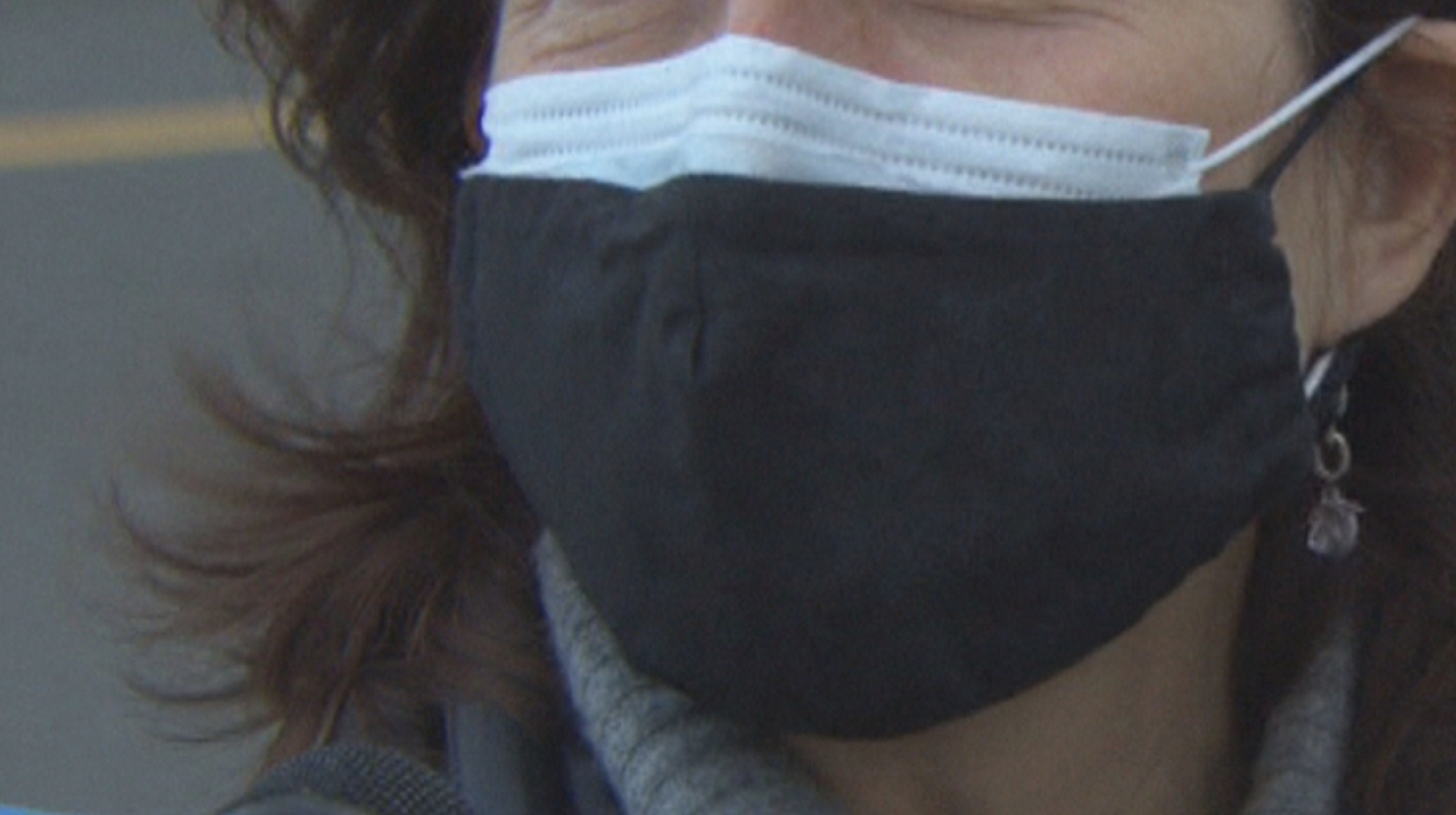 A woman is seen wearing two masks to try to prevent the spread of COVID-19.