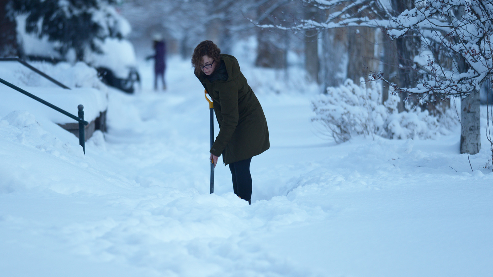 Leigh Ann Ellis de Denver balaie la neige des trottoirs devant sa maison à Denver le 25 février 2021.