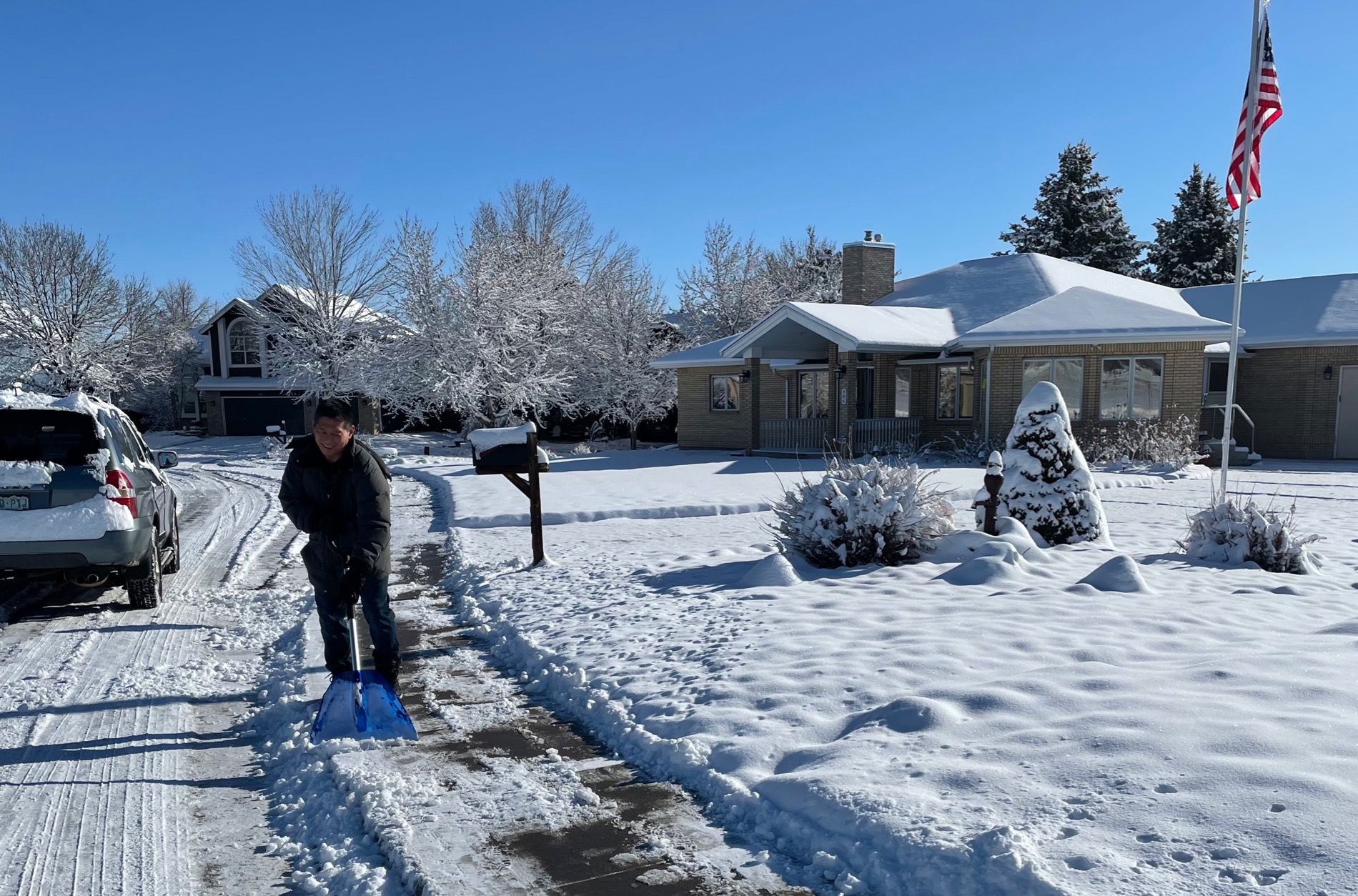 A resident in eastern Boulder County shovels his sidewalk.