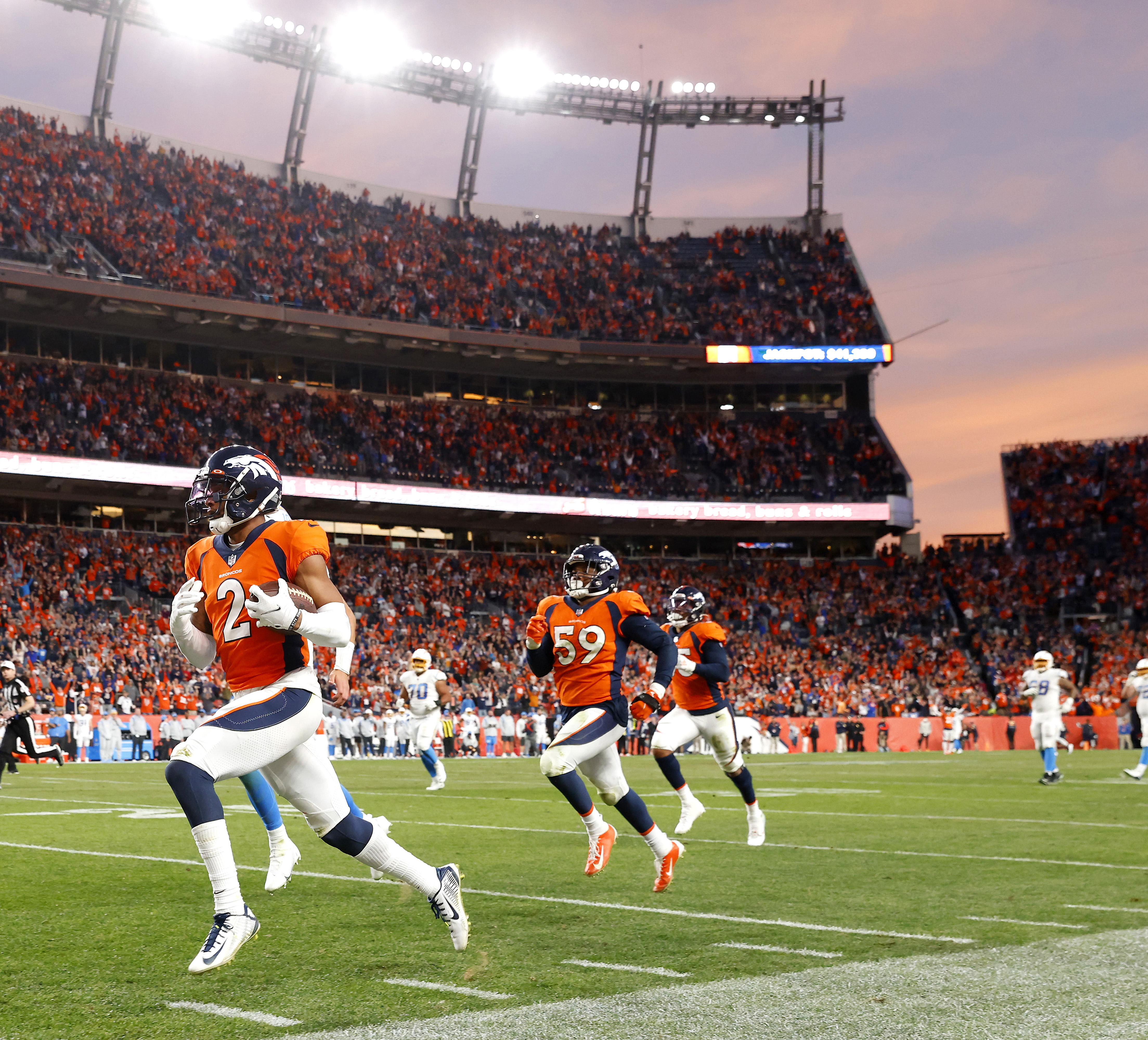Pat Surtain II of the Denver Broncos carries the ball into the end zone for a touchdown against the Los Angeles Chargers at Empower Field At Mile High on November 28, 2021. 