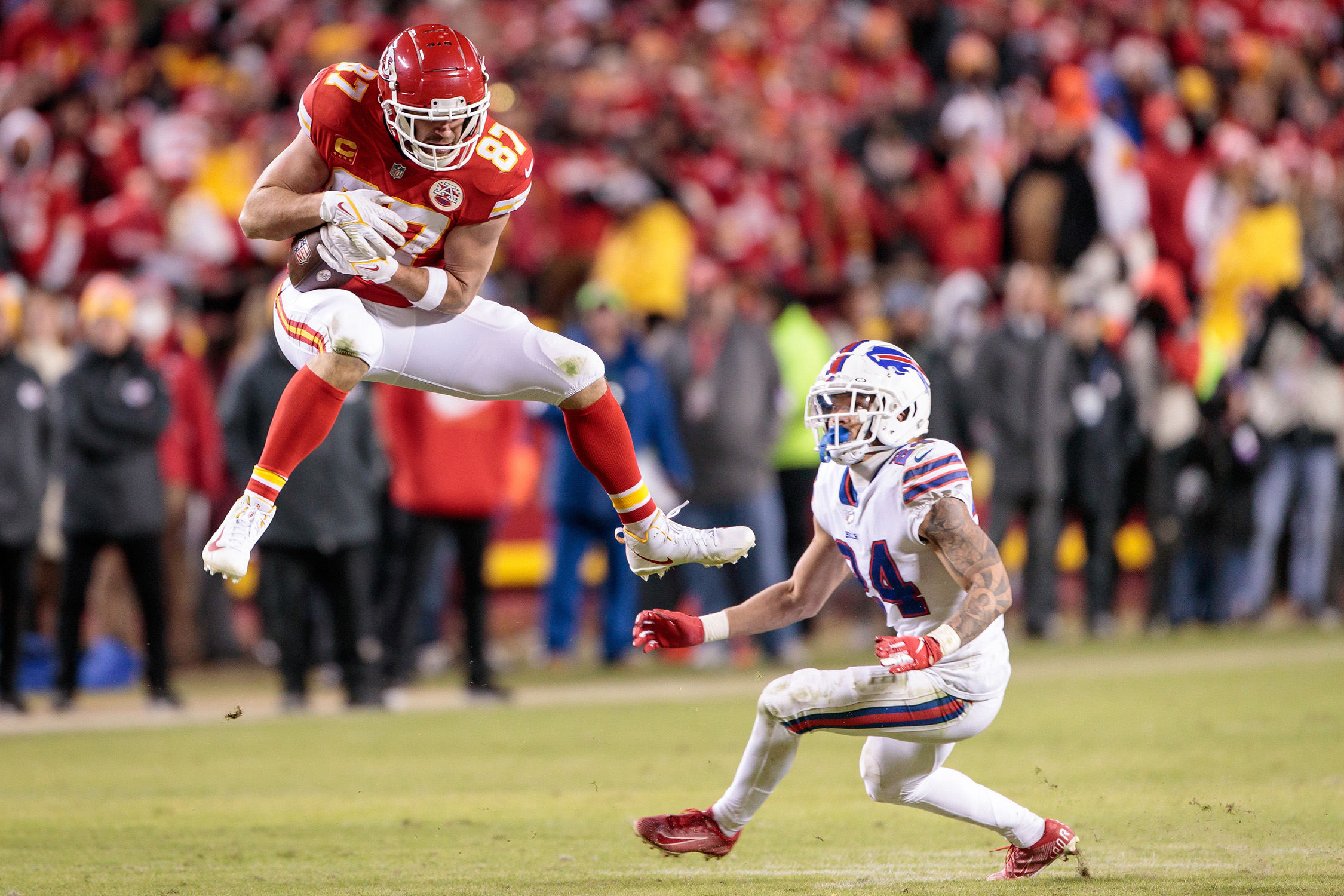Kansas City Chiefs tight end Travis Kelce leaps for a reception over Buffalo Bills cornerback Taron Johnson during the AFC Divisional Round playoff game on Jan. 23, 2022 at Arrowhead Stadium in Kansas City, Missouri. 