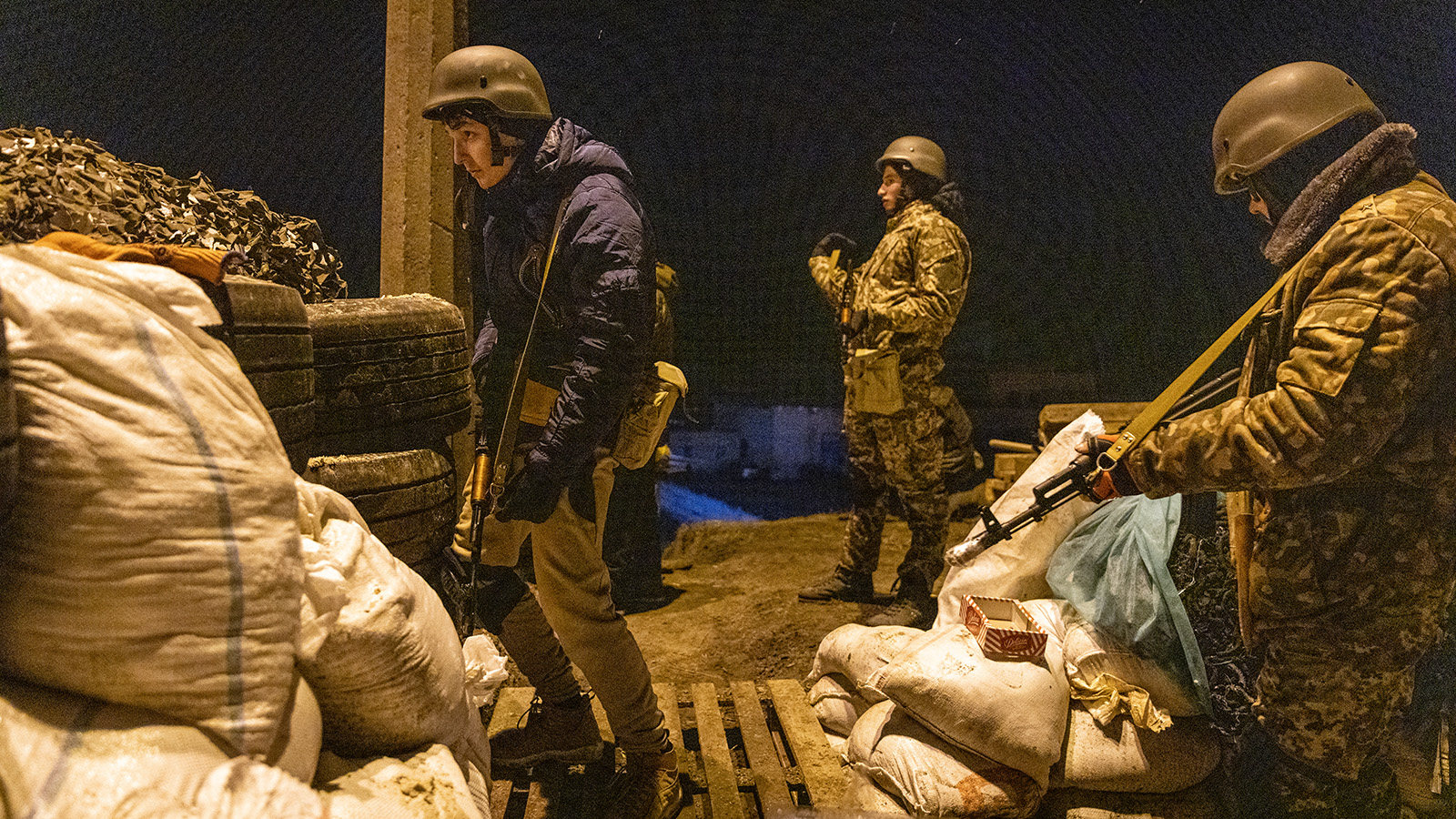 Members of a territorial defense unit watch as a car approaches their barricade after curfew on the outskirts of eastern Kyiv on March 6, 2022 in Kyiv, Ukraine.  Russia is continuing its assault on major Ukrainian cities, including the capital Kiev, more than a week after launching a full-scale invasion of the country.